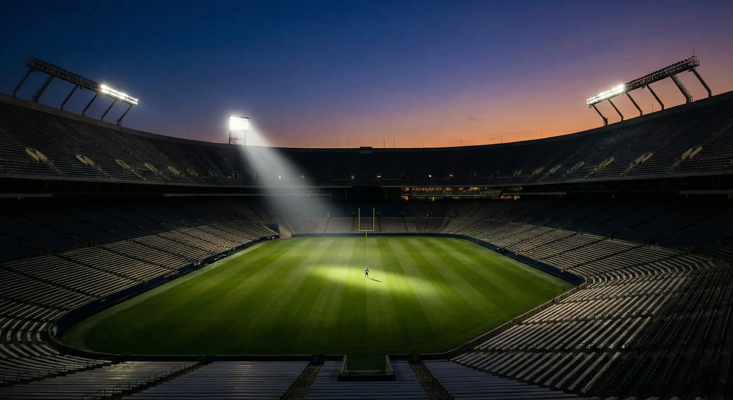 Empty stadium at dusk with dramatic spotlight - Sports Romance genre
