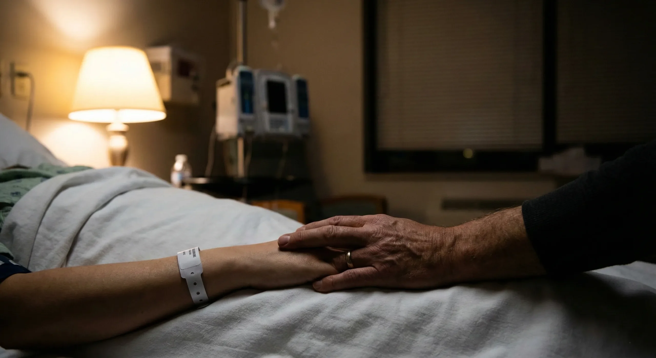 Hospital room at night with soft lamp glow and hand being held - Hurt Comfort romance trope