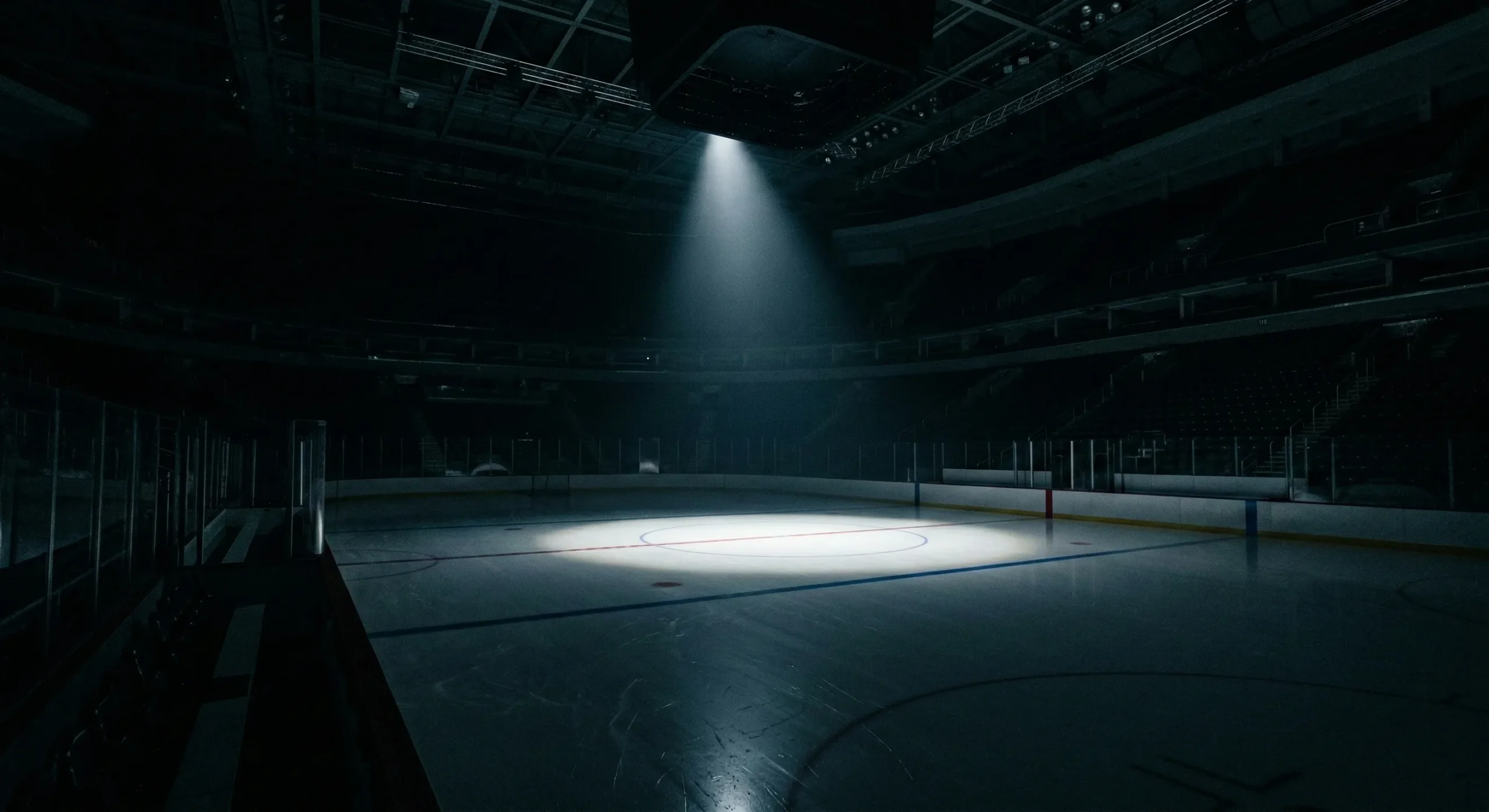 Empty hockey rink at night with single spotlight on center ice - why hockey is the perfect sport for enemies to lovers romance